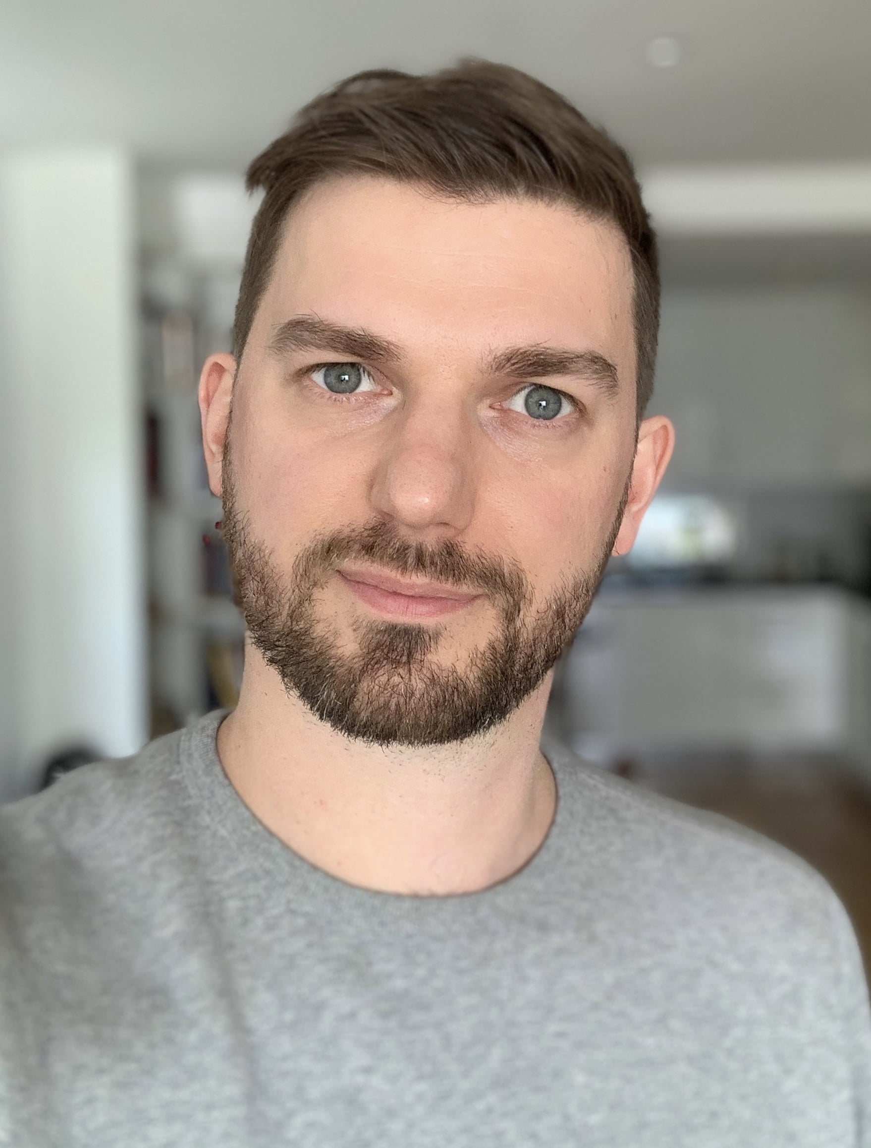 A picture of a white man called Rob James with black hair and a beard smiling out towards the camera. He is wearing a great t-shirt.